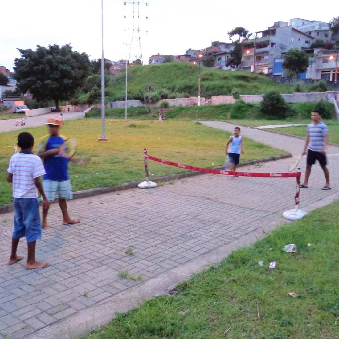 Crianças jogando tênis improvisado em uma rua da comunidade